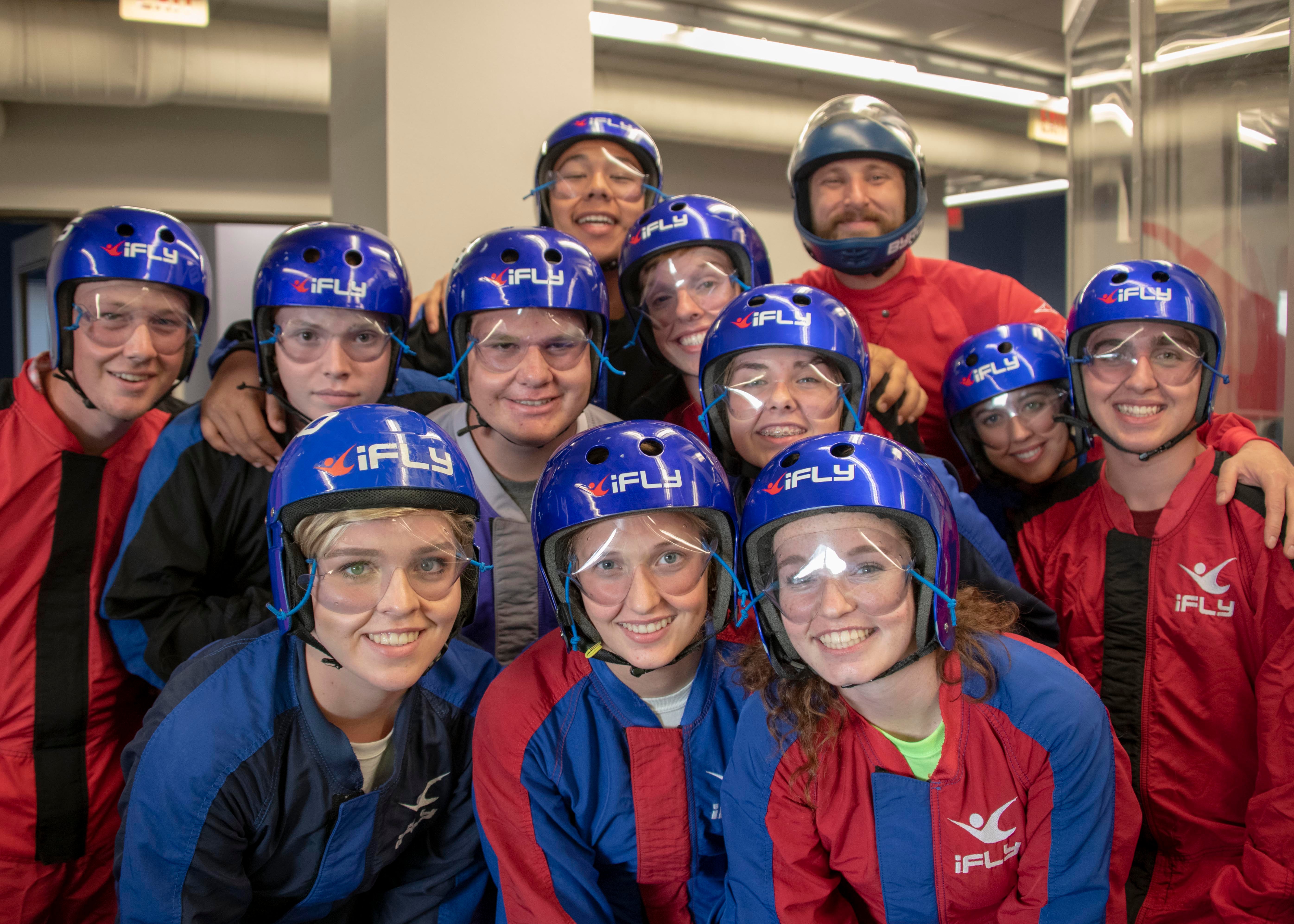 Group photo at iFly with everyone in flight suits and helmets